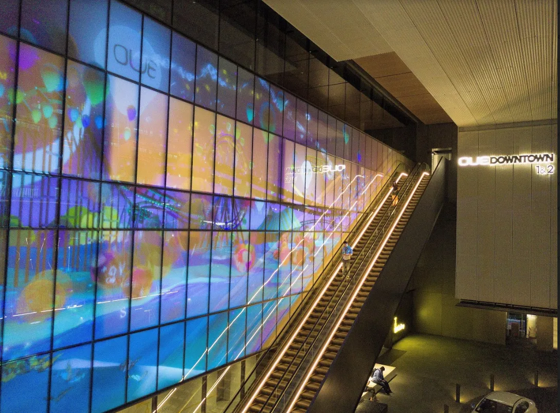 Transparent LED display beside an escalator